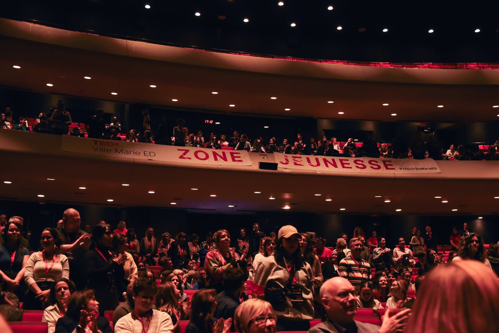 Vue de la salle comble avec la bannière Zone jeunesse au balcon, édition précédente