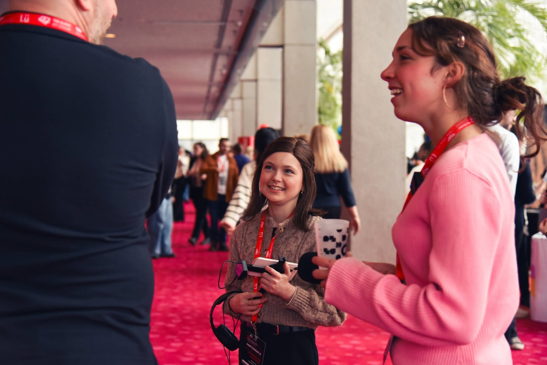 Jeune journaliste interviewant des participants dans le hall de l’événement